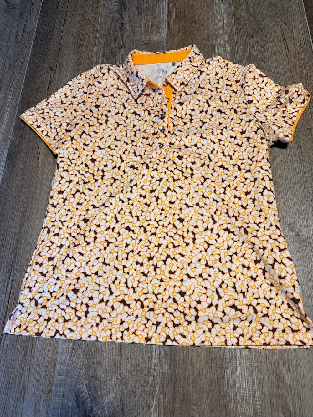 Nivo Sports women's polo shirt features an orange floral pattern